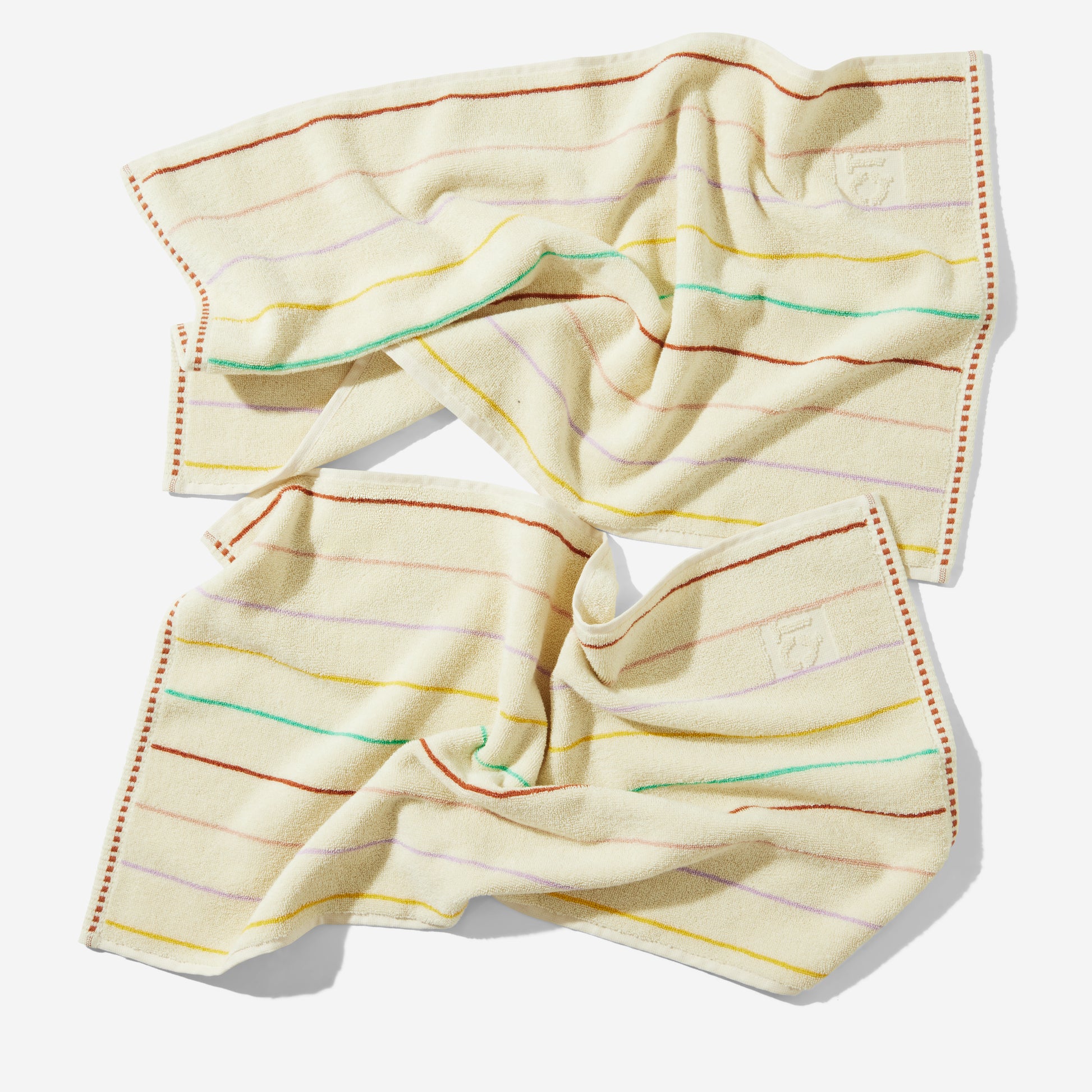 Prism hand towels with multi-color prism stripes laid out on floor.