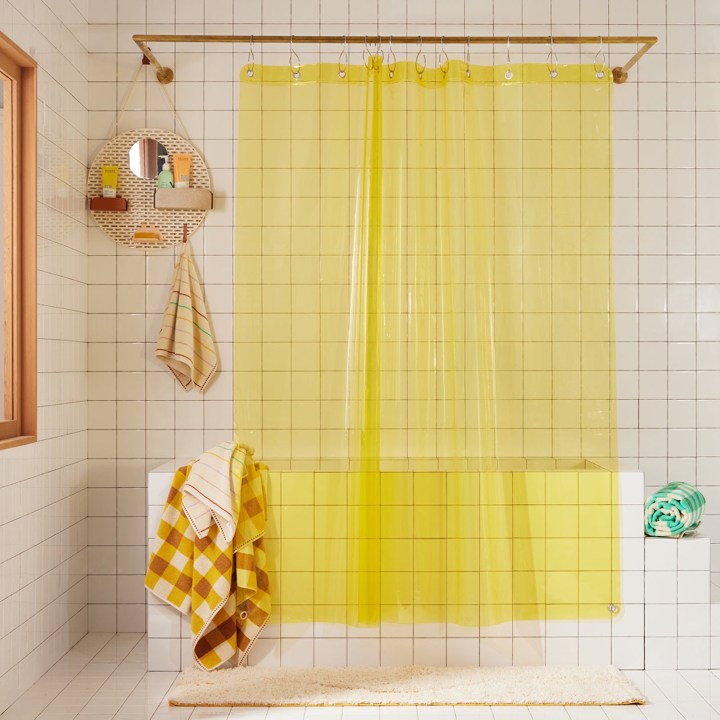 Sun shower curtain in sunny hanging over bathtub styled in a white tiled bathroom with atlas canyon.