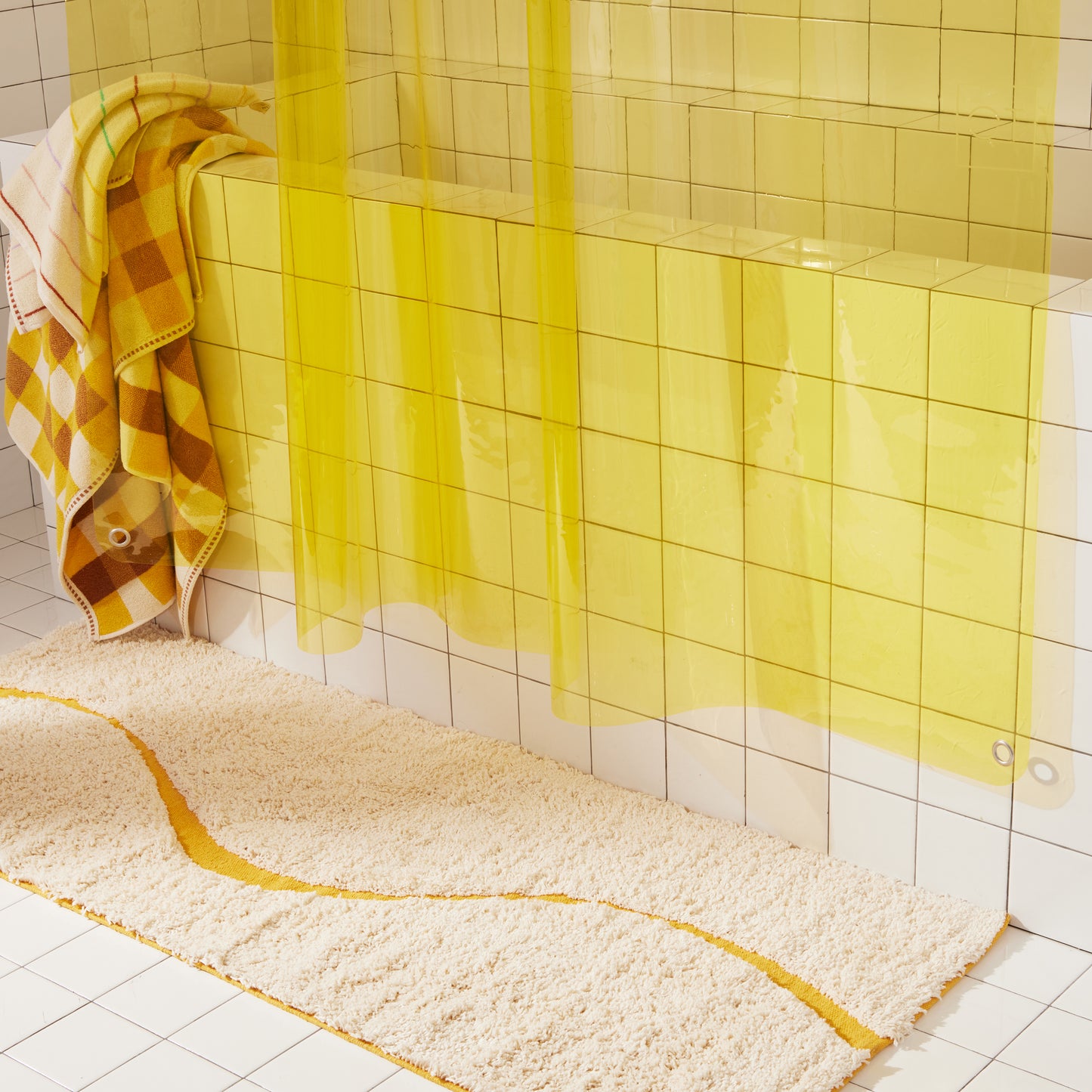 Bottom half of Sunny Sun Shower curtain styled with Atlas Canyon bath runner, Tam Canyon bath sheet and Prism hand towel. Also featuring the bottom grommet of Sunny Sun Shower in nickel.