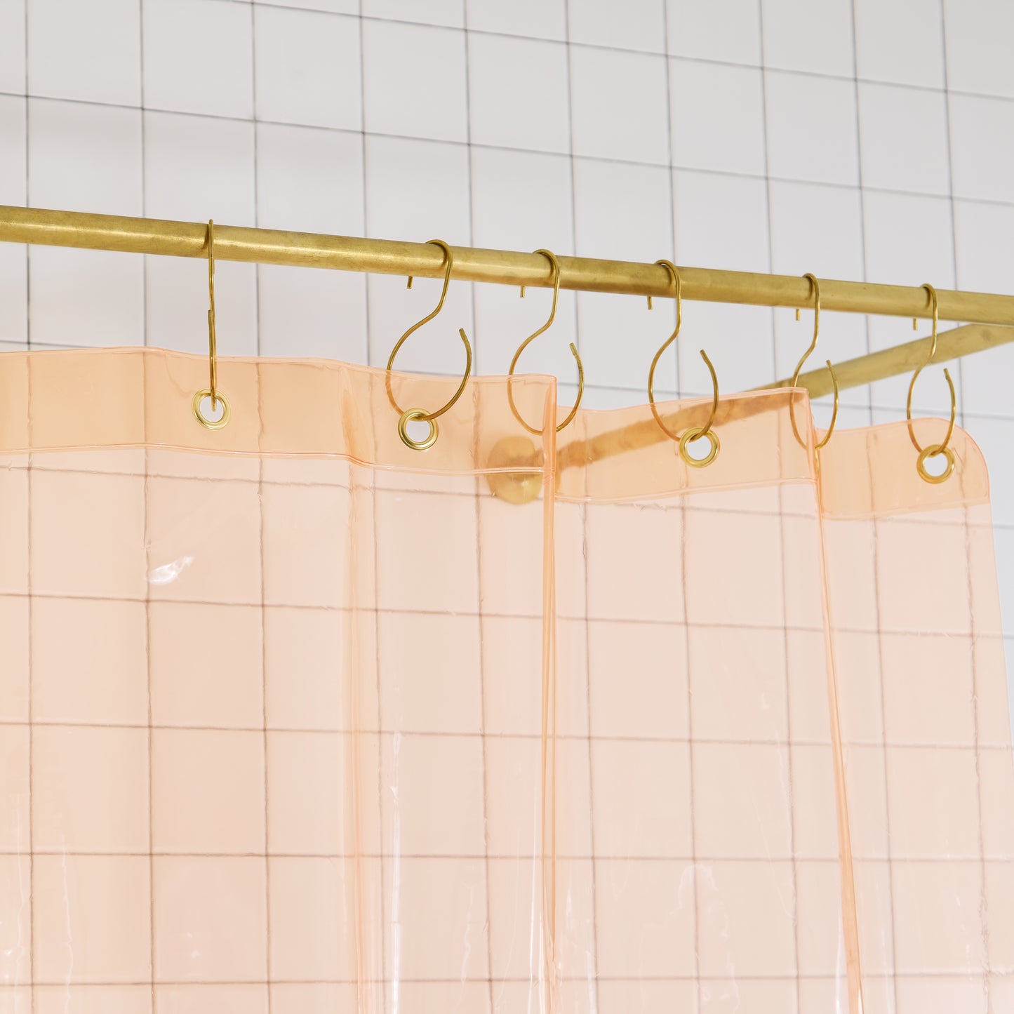 Sun Shower Cloud detail view of grommets and hooks hanging from shower curtain rod.