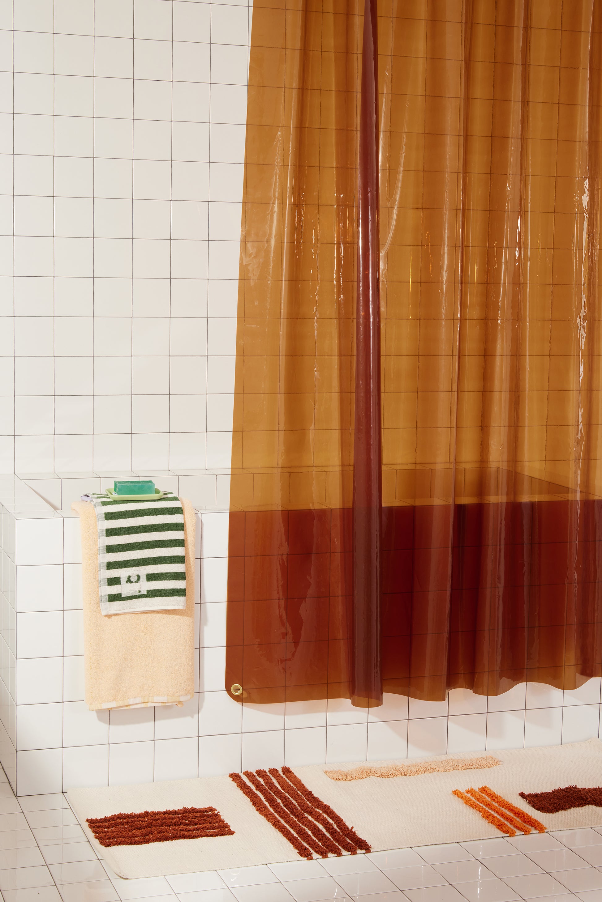 Sun Shower Honey detail view of front corner of curtain hanging in a bathroom.