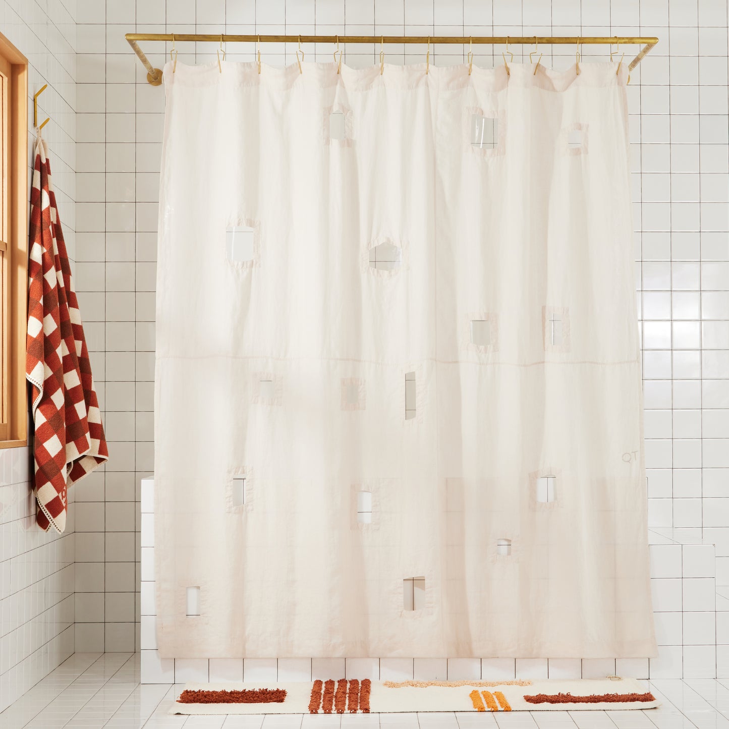 Ronchamp linen shower curtain in sand with different sized rectangular window cut-outs hangs in white tiled bathroom.
