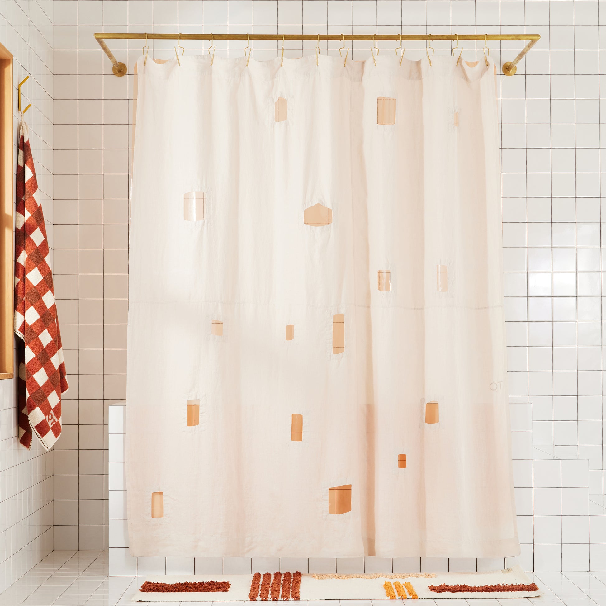 Full view of ronchamp linen shower curtain in sand in white tiled bathroom.
