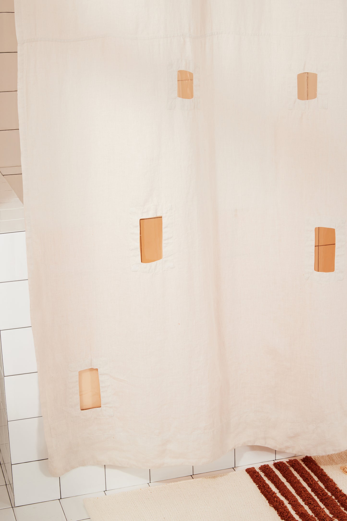 Rectangular cutouts of ronchamp curtain show sun shower curtain light coming through.