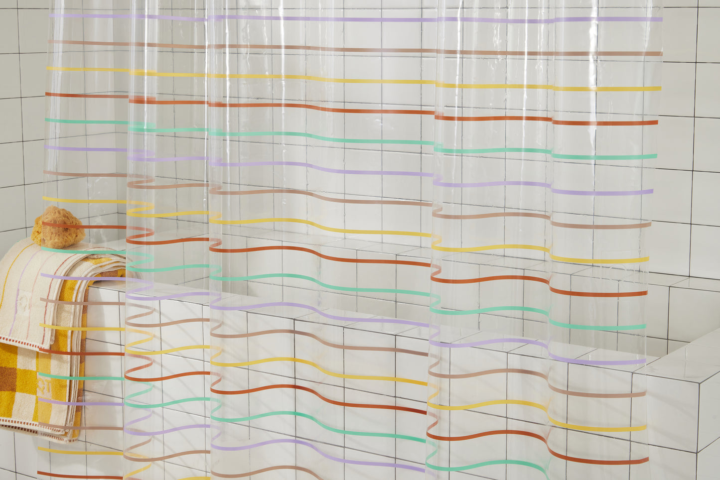 Middle of shower curtain featuring the horizontal stripes of our Prism shower curtain which are green, lavender, rose, yellow, clay and our Prism hand towel and Tam Canyon bath sheets.
