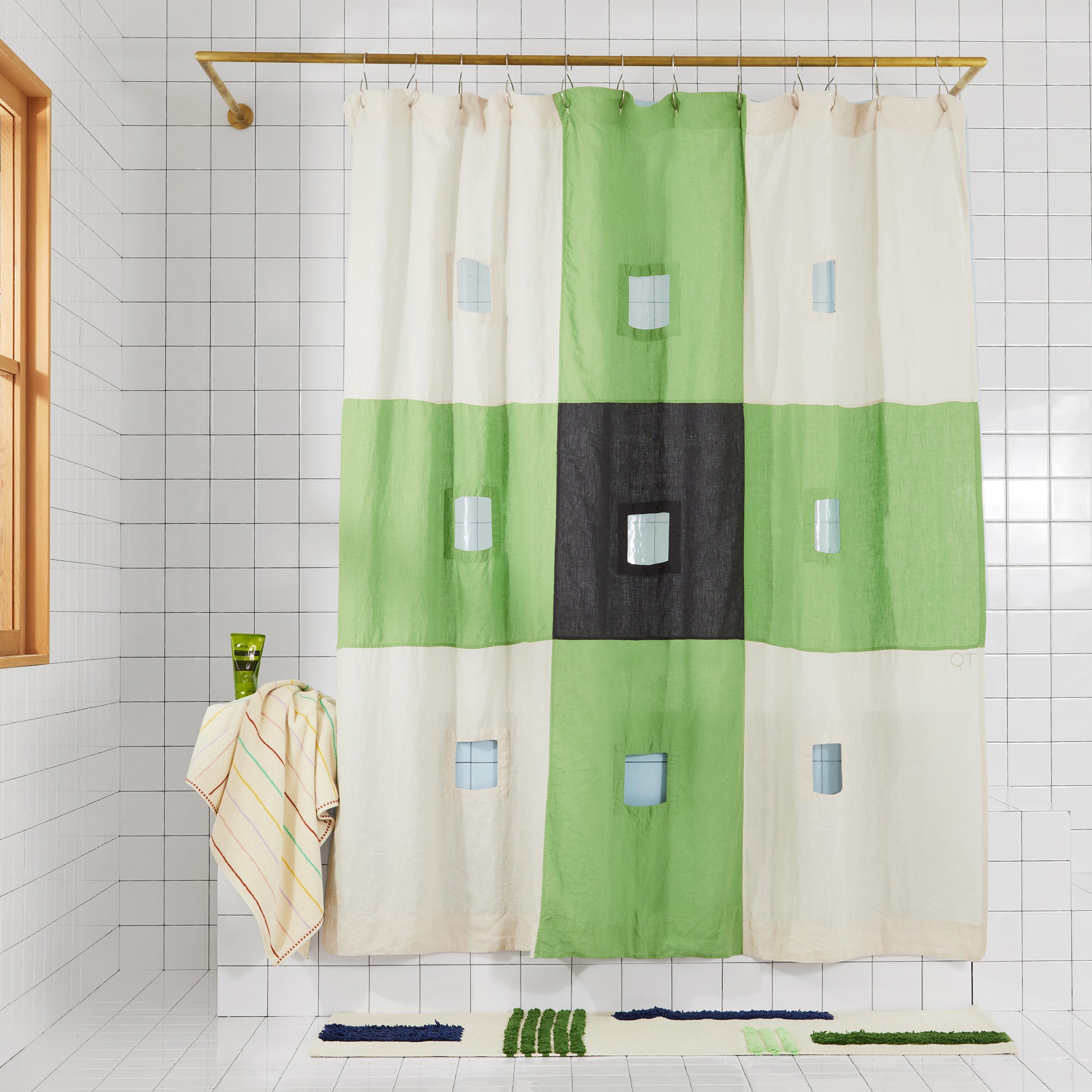 photo of green and charcoal checker linen curtain henging in bathroom.