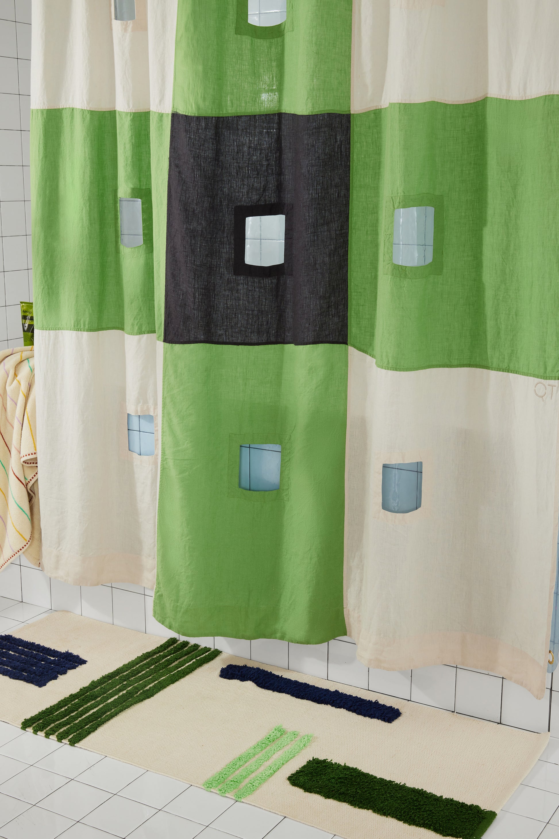 photo of lower half of green and checker curtain hanging in bathroom.