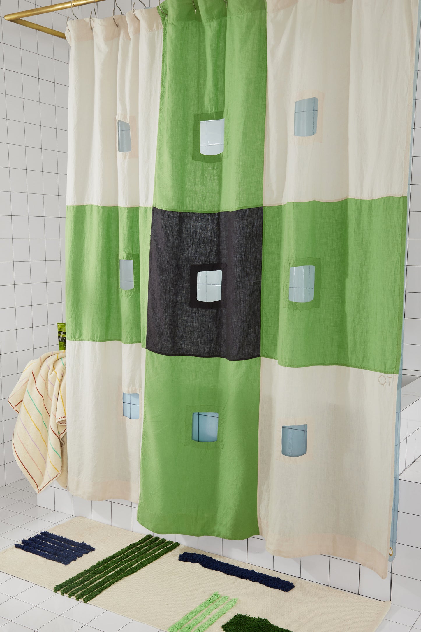 photo of green and checker linen curtain with green striped rug and towel.