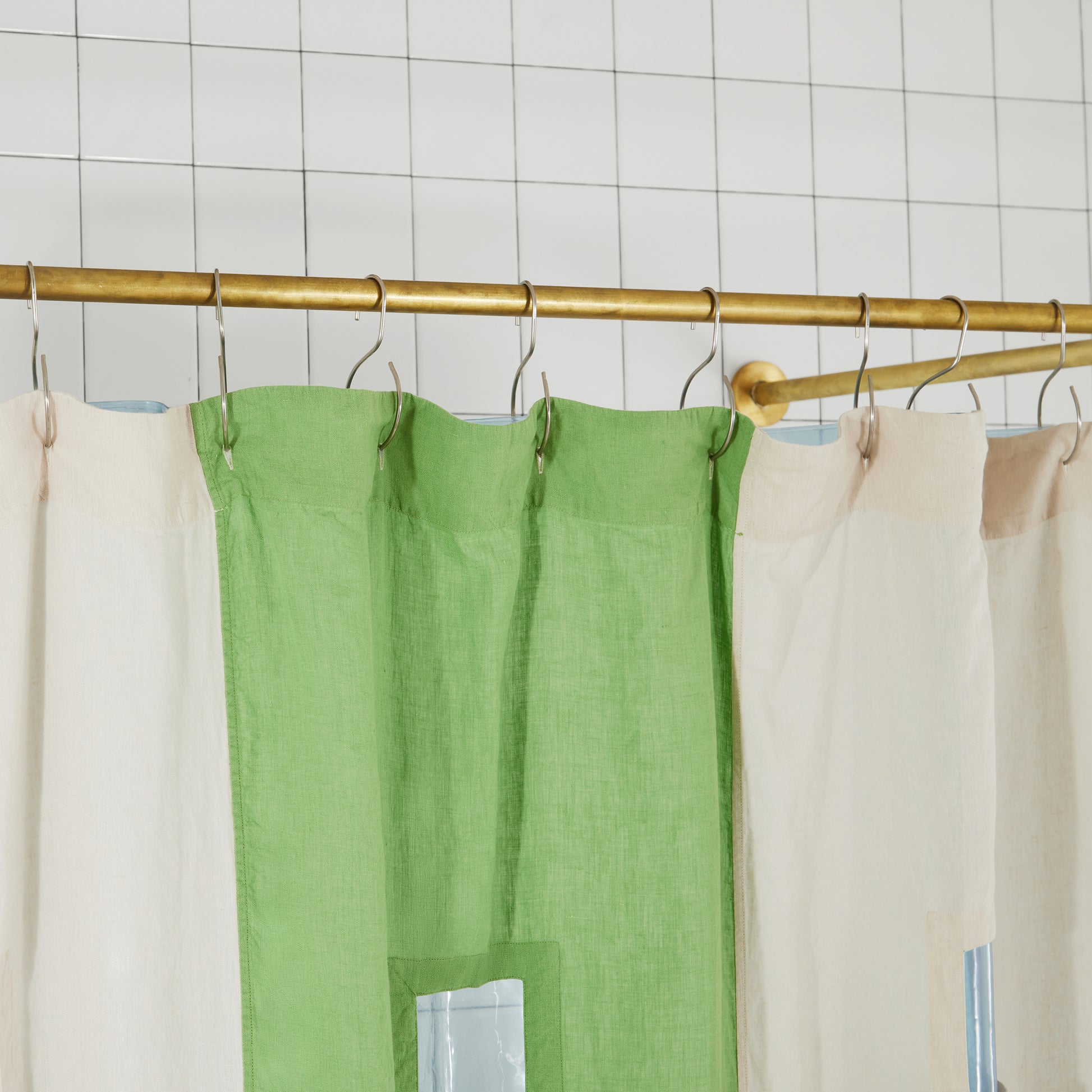 photo of top hem of green linen curtain with button holes and shower curtain hooks