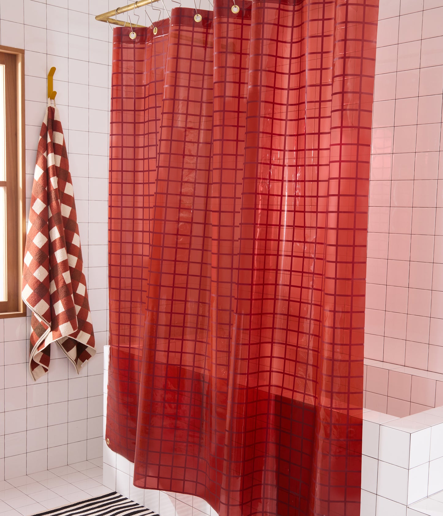 Side shot of 2x2 sun shower curtain in brick styled with brown checked towel.