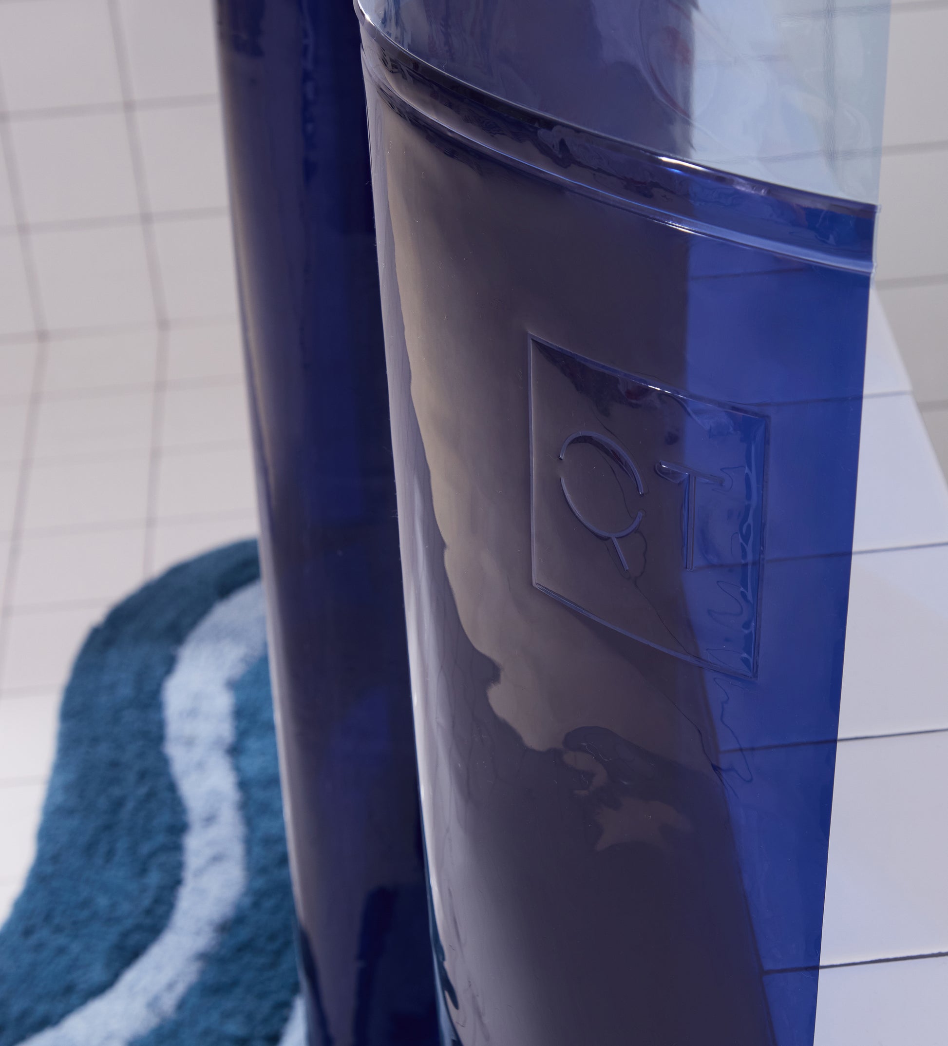 Deep sea orient sun shower curtain detail view of the Quiet Town logo embossed on the shower curtain.