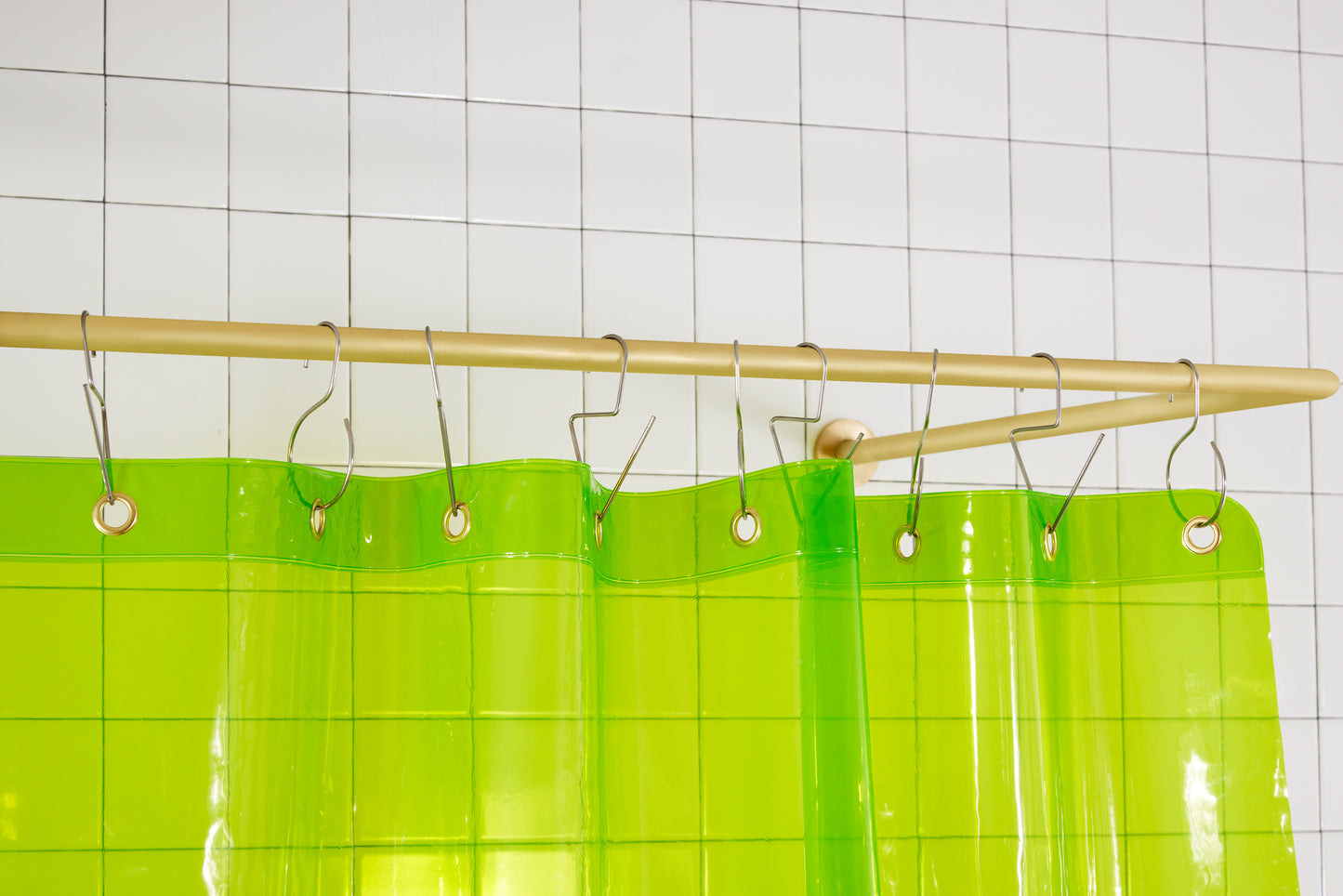 Sun Shower Lime detail view of grommets and hooks hanging from shower curtain rod.