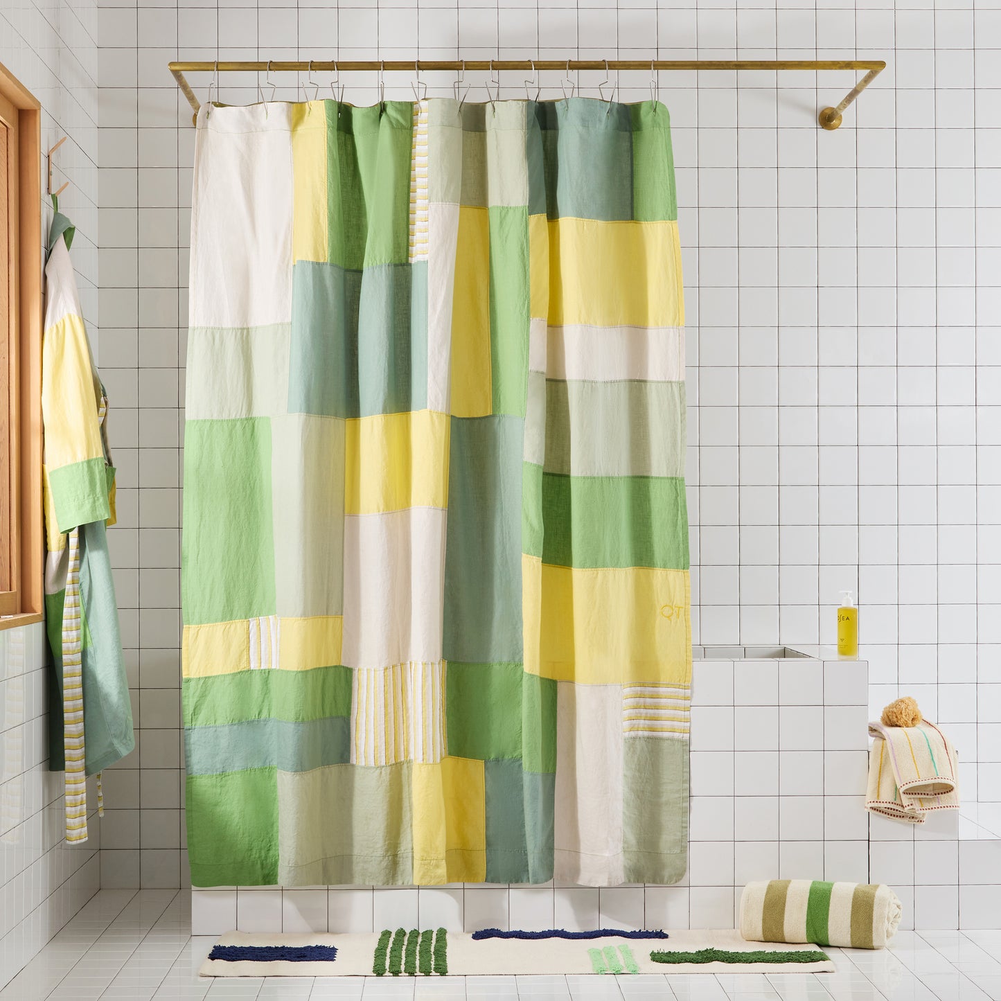 Green and yellow checkered shower curtain in a bathroom setting with matching bath mats.