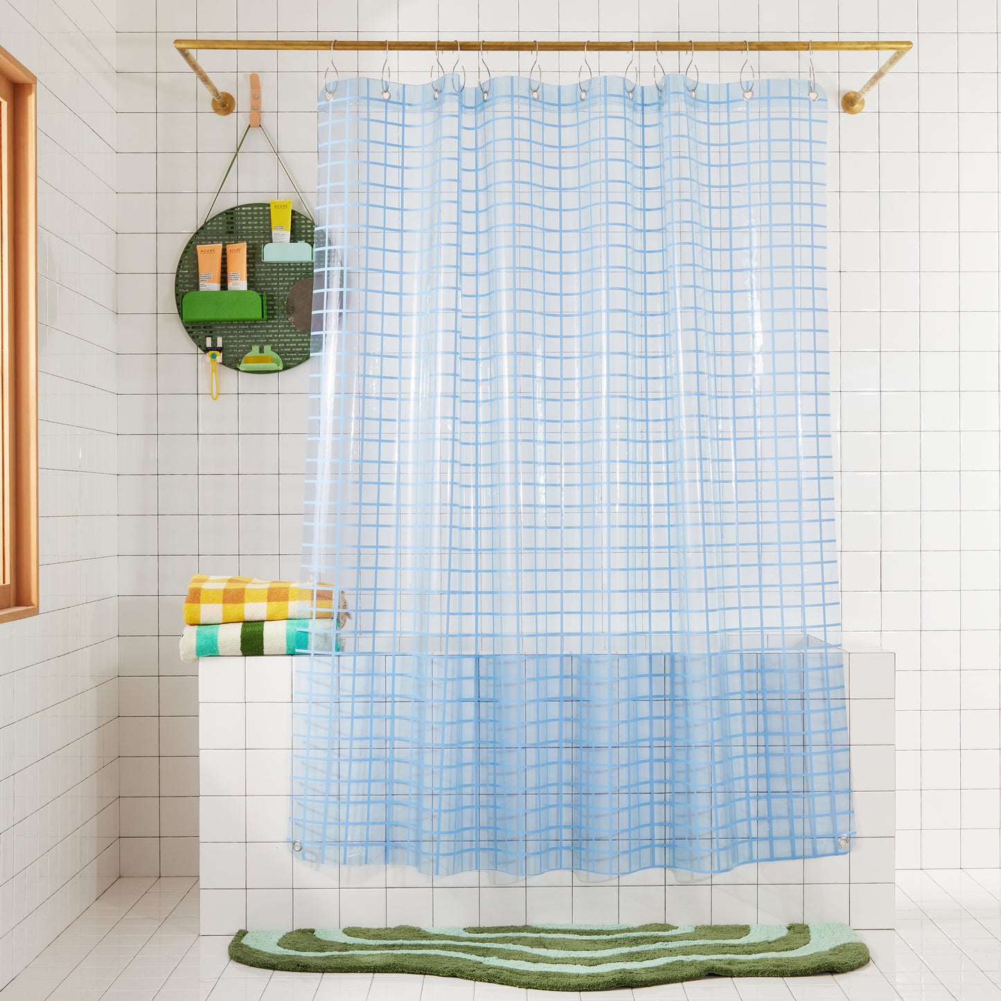 2x2 sun shower curtain in atlantic hanging in a white tiled bathroom styled with the spot in green and lost coast bath mat in grass.