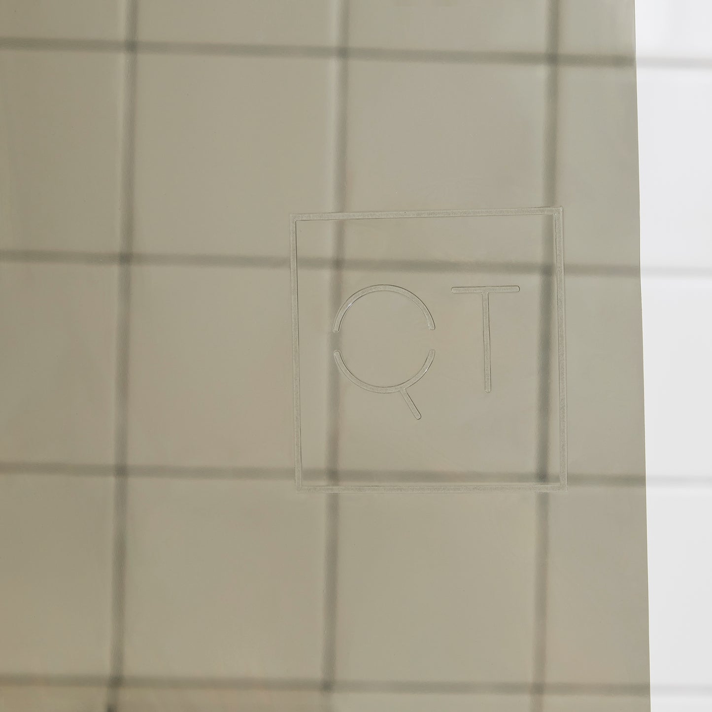 Sun Shower Night Ride Detail view of the Quiet Town logo embossed on the shower curtain.