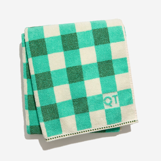 Tam bath sheet in pine folded against white backdrop.