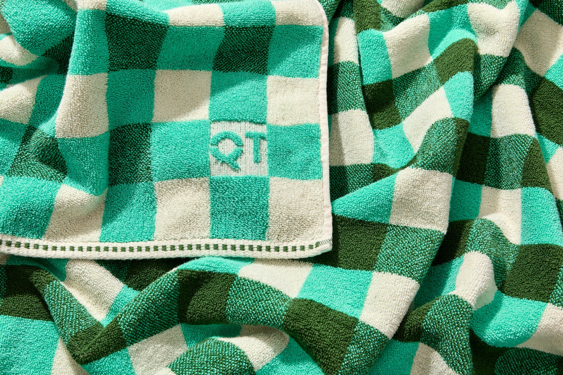 Tam bath sheet in pine with embossed QT logo on the corner.