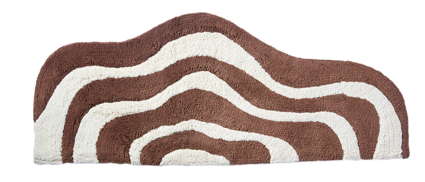 Wave shaped brown and cream striped bath mat runner in 56"x22" size with white background.