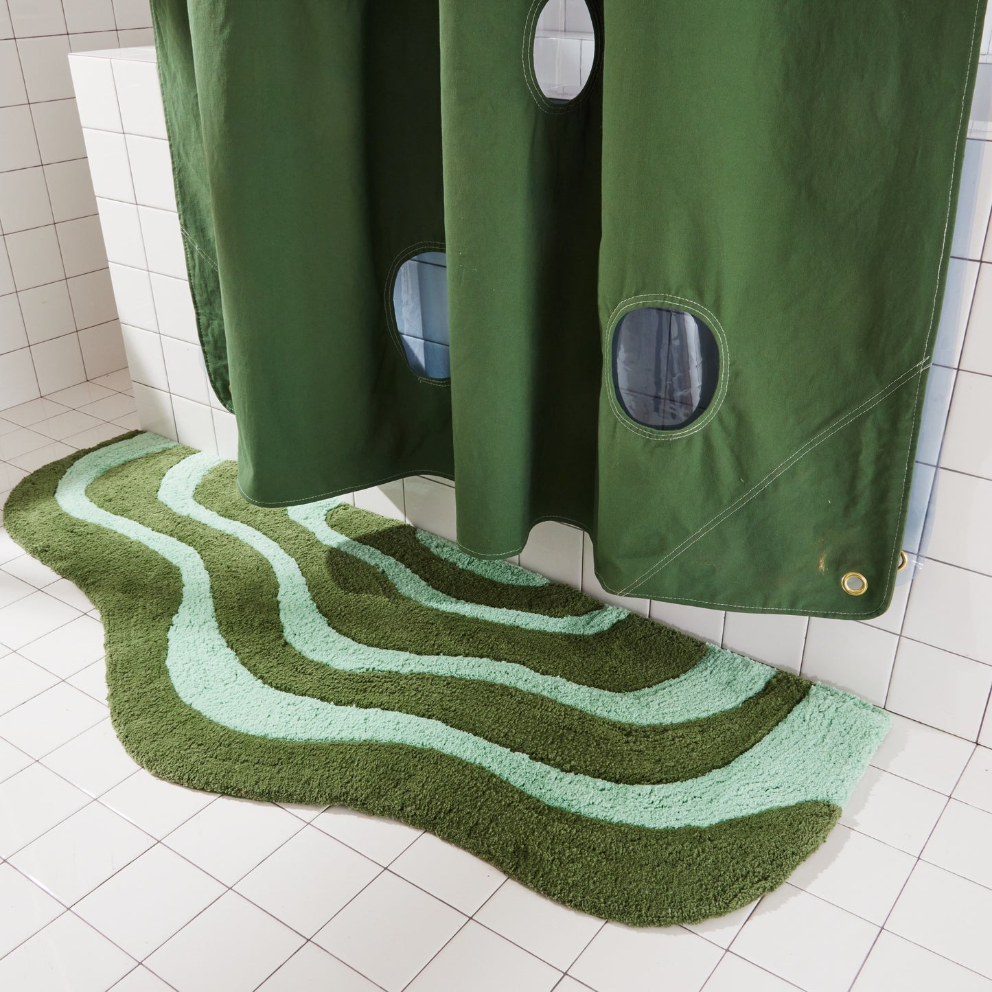 Wave shaped pine and jade striped bath mat runner in 56"x22" size styled under bubble shower curtain.