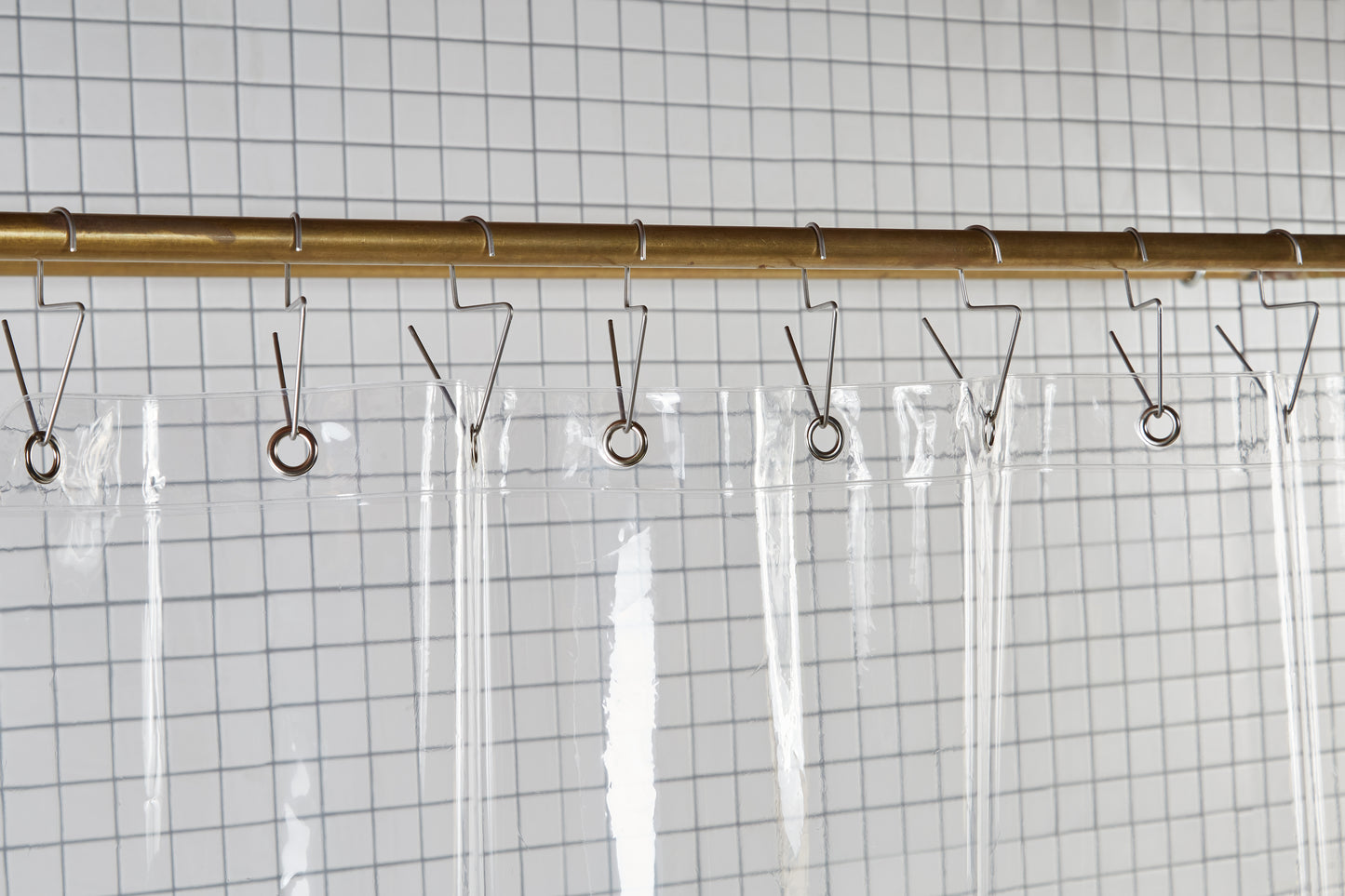 Sun Shower Air detail view of grommets and hooks hanging from shower curtain rod.