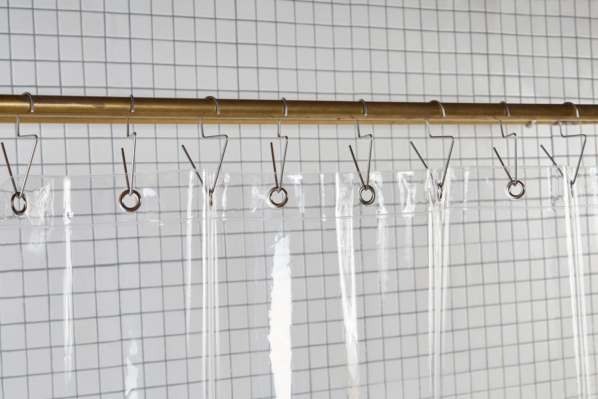 Sun Shower Air detail view of grommets and hooks hanging from shower curtain rod.