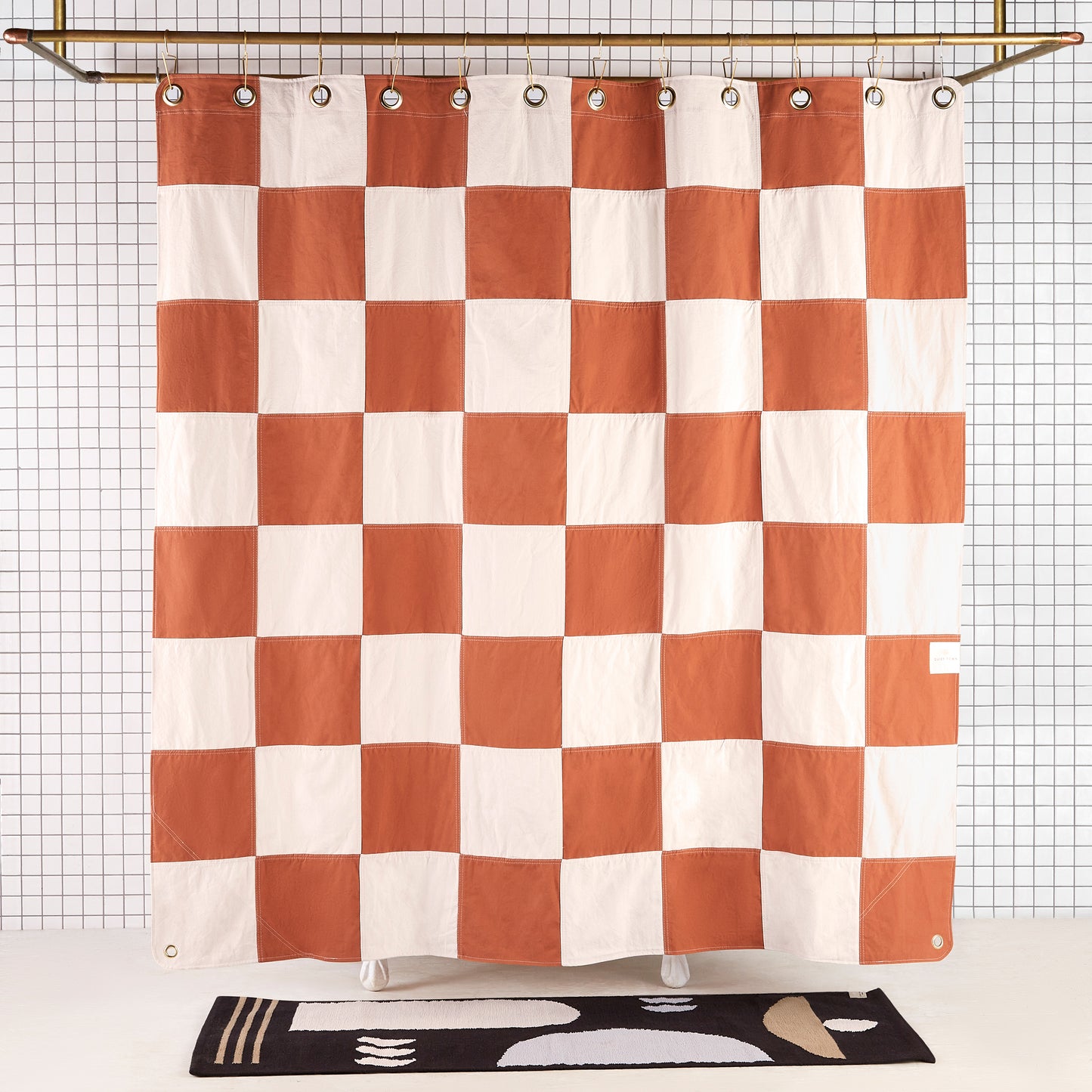 Re:Canvas Checker Clay front view of curtain hanging in a bathroom.