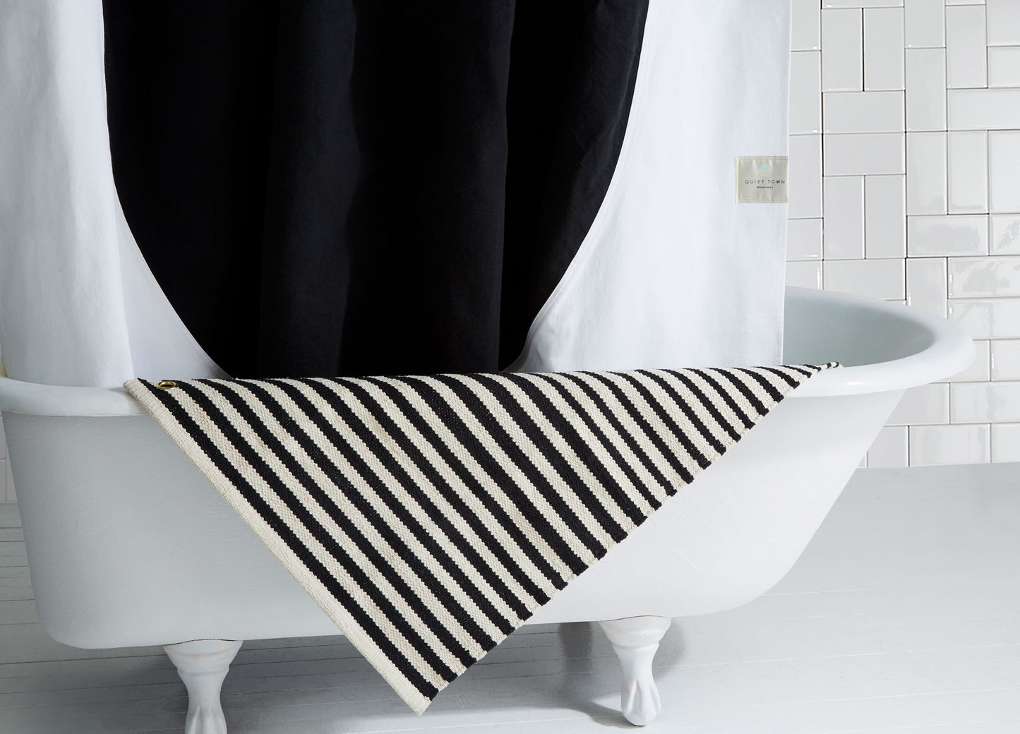 Ojai Night Ride bath rug draped on edge of bath tub