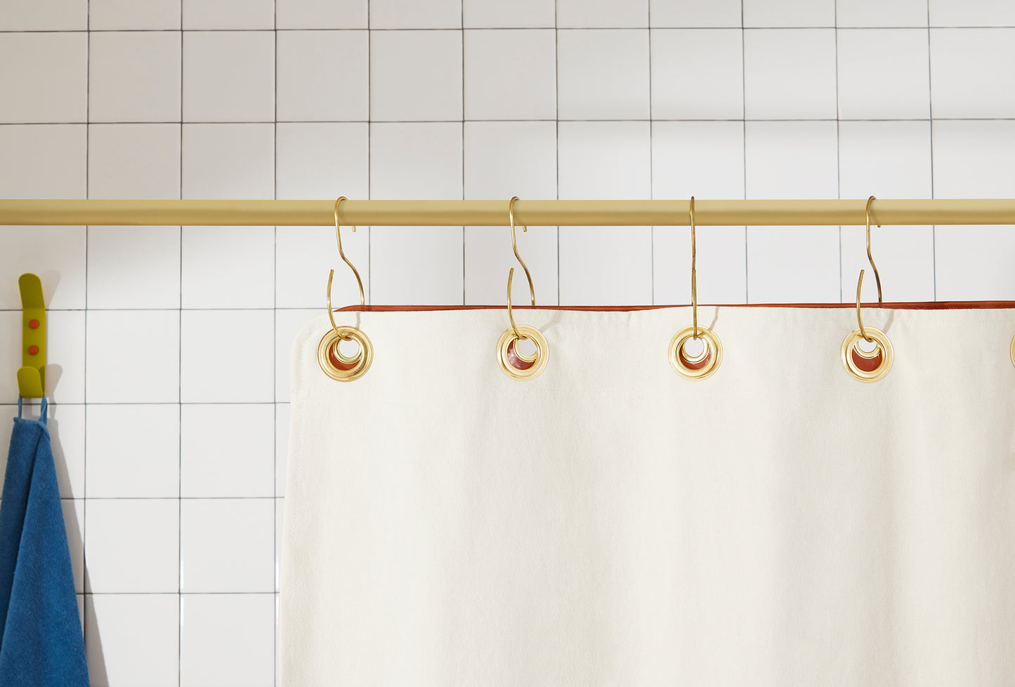 Orient Hesse detail view of grommets and hooks hanging from shower curtain rod.