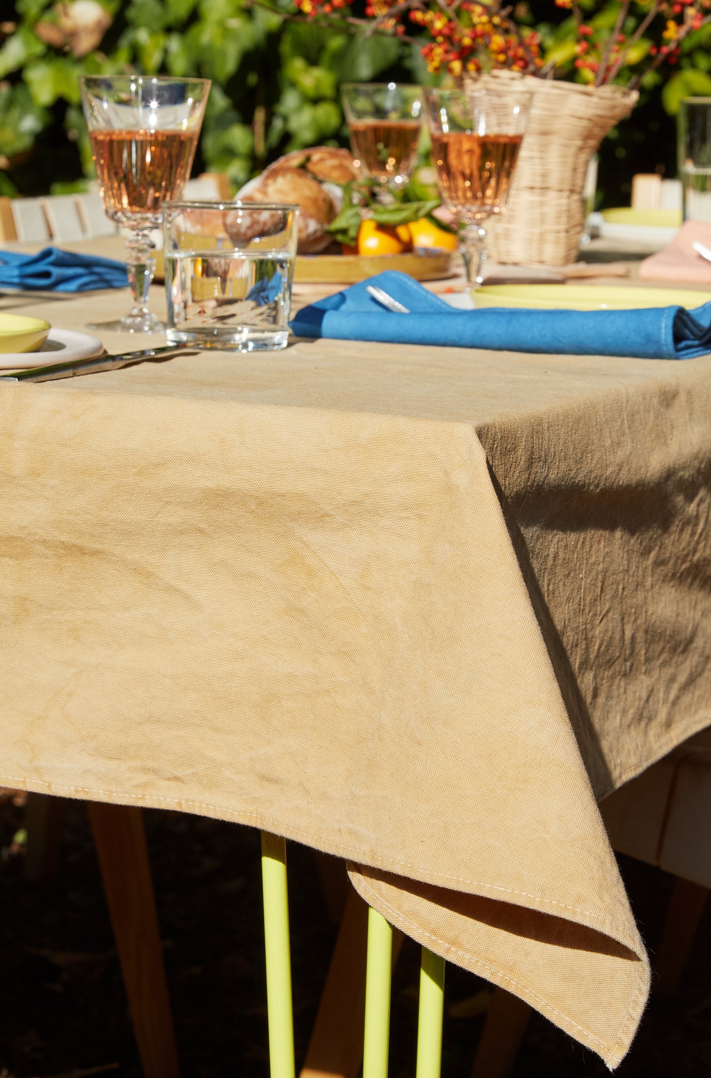 Naturally Dyed Tablecloth for 8 in Eucalyptus detail view draped on the edge of table