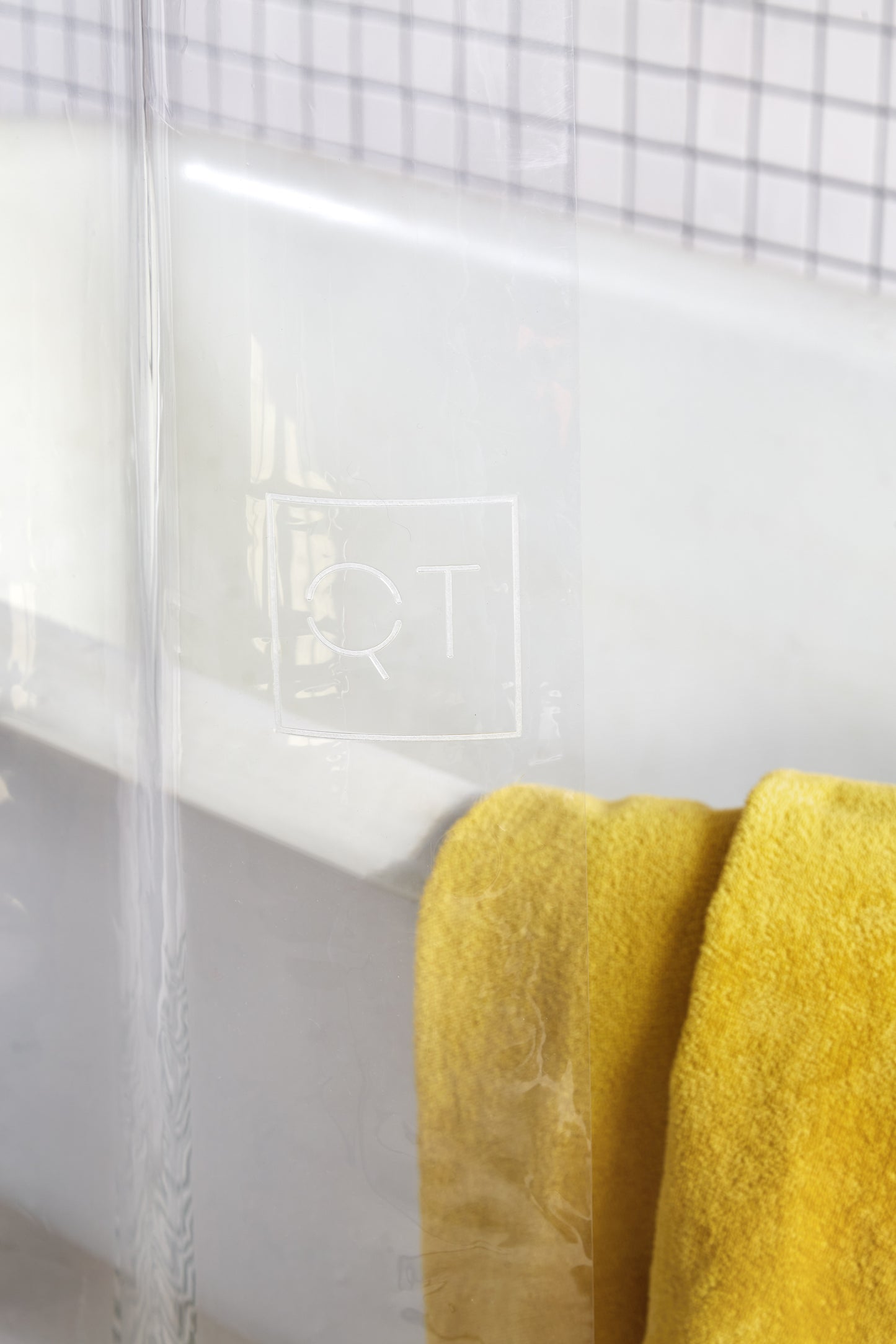 Sun Shower Air Detail view of the Quiet Town logo embossed on the shower curtain.