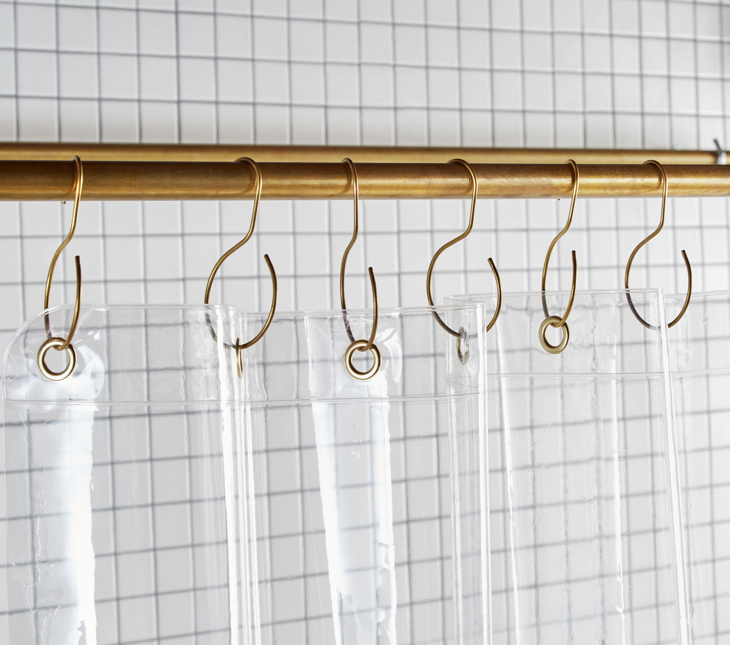 Sun Shower Air detail view of grommets and hooks hanging from shower curtain rod.