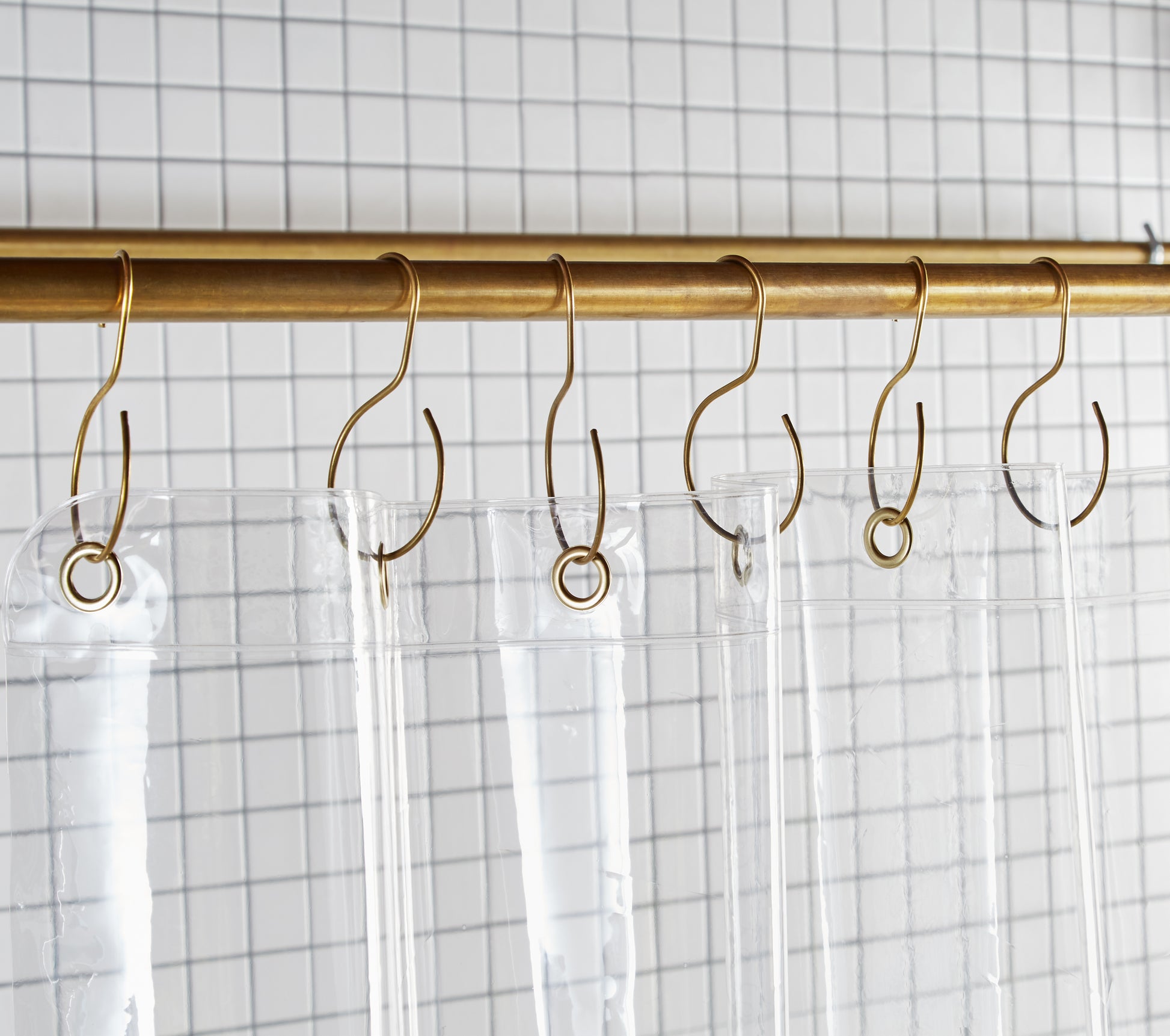 Sun Shower Air detail view of grommets and hooks hanging from shower curtain rod.
