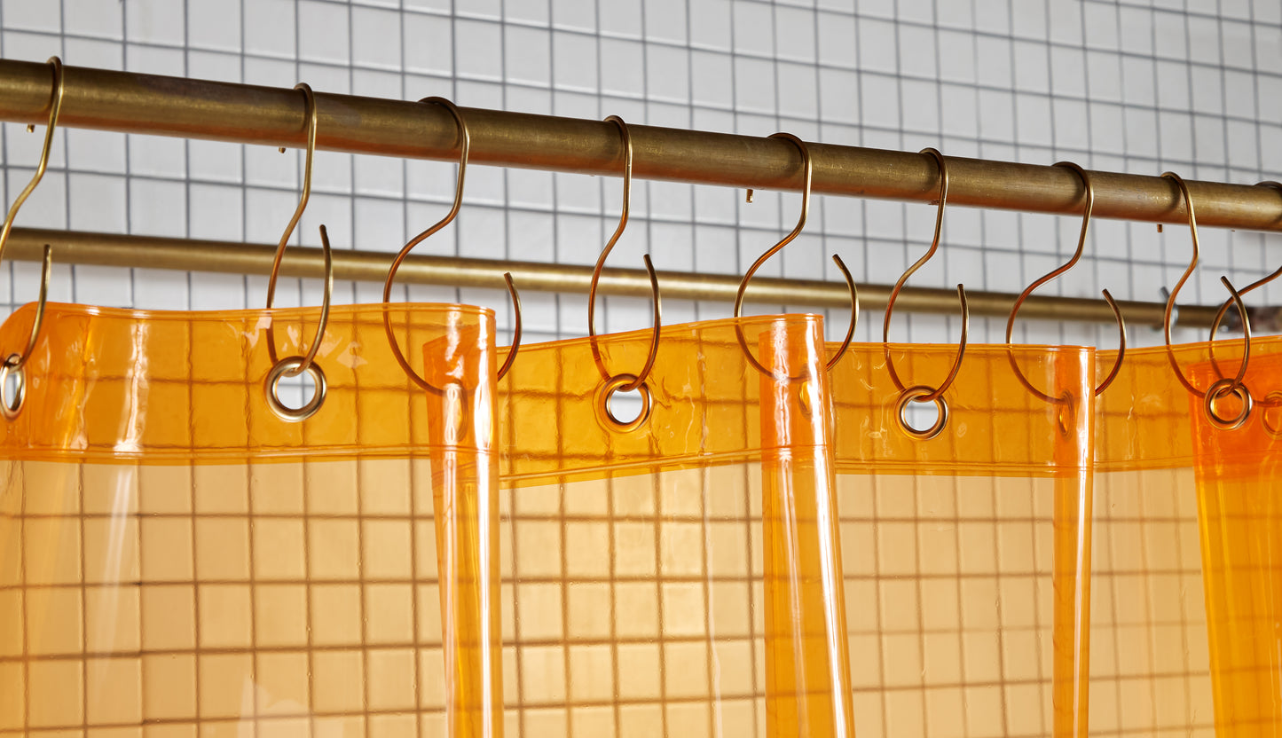 Sun Shower Juice view of grommets and hooks hanging from shower curtain rod.