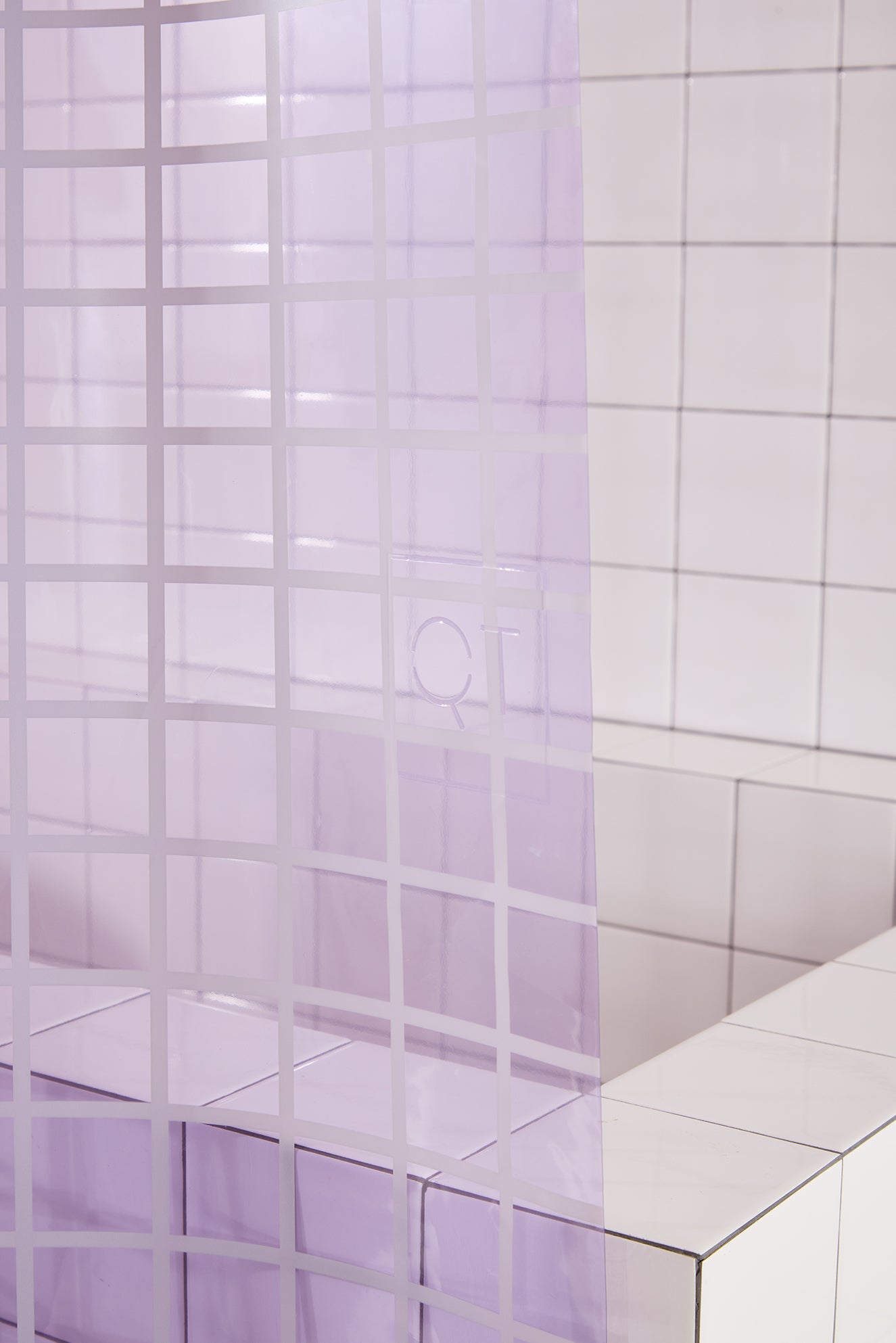 Close-up of a tiled wall with a grid pattern curtain