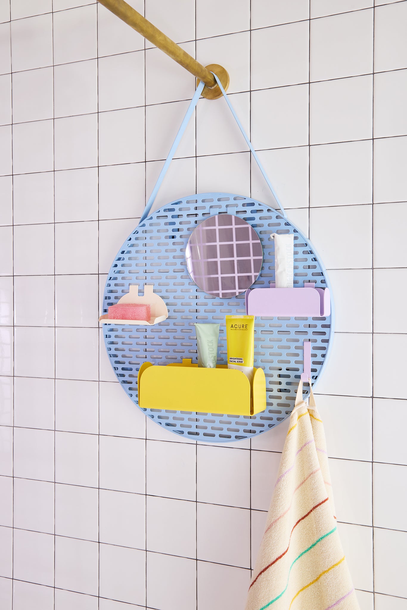 Shower caddy with various items hanging on a tiled shower wall.