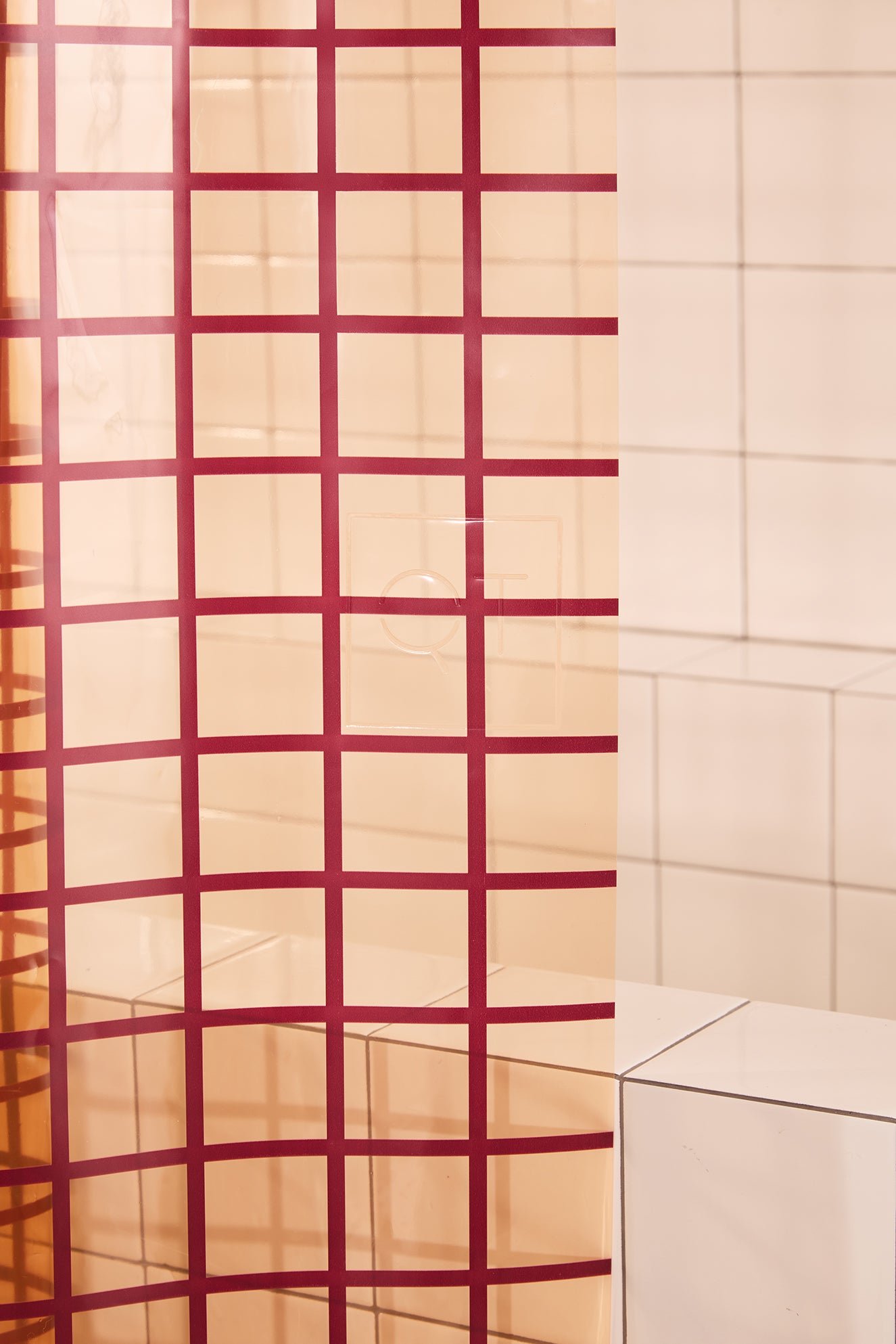 Red grid-patterned shower curtain in a bathroom setting