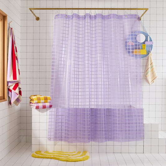 Lavender grid-patterned shower curtain in a bathroom with tiled walls and colorful towels.