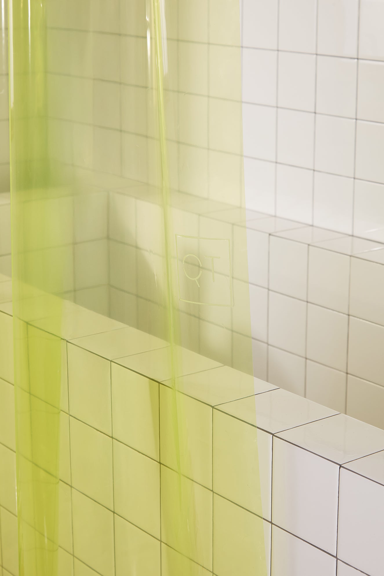 Shower area with a yellow-green shower curtain and tiled walls.