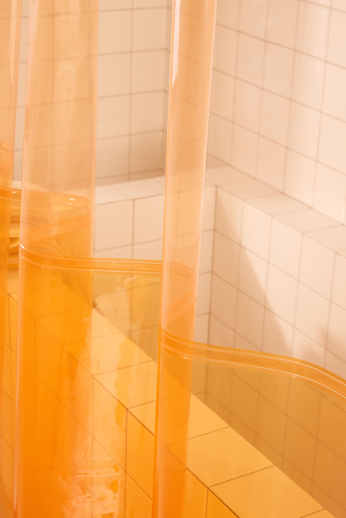 Orange shower curtain in a tiled bathroom