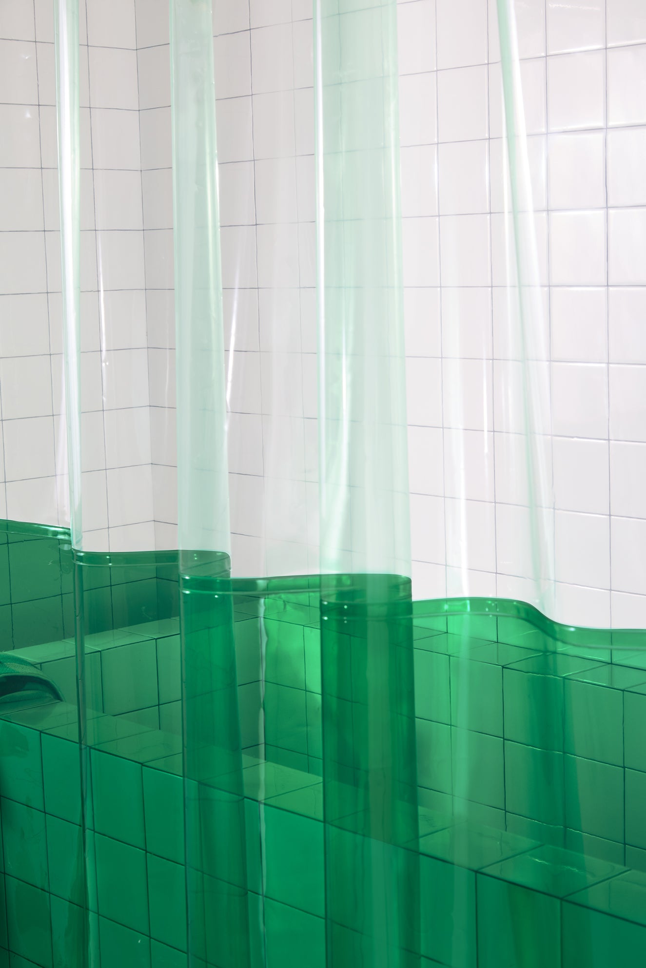 Bathroom with white tiled walls, featuring a green shower curtain.