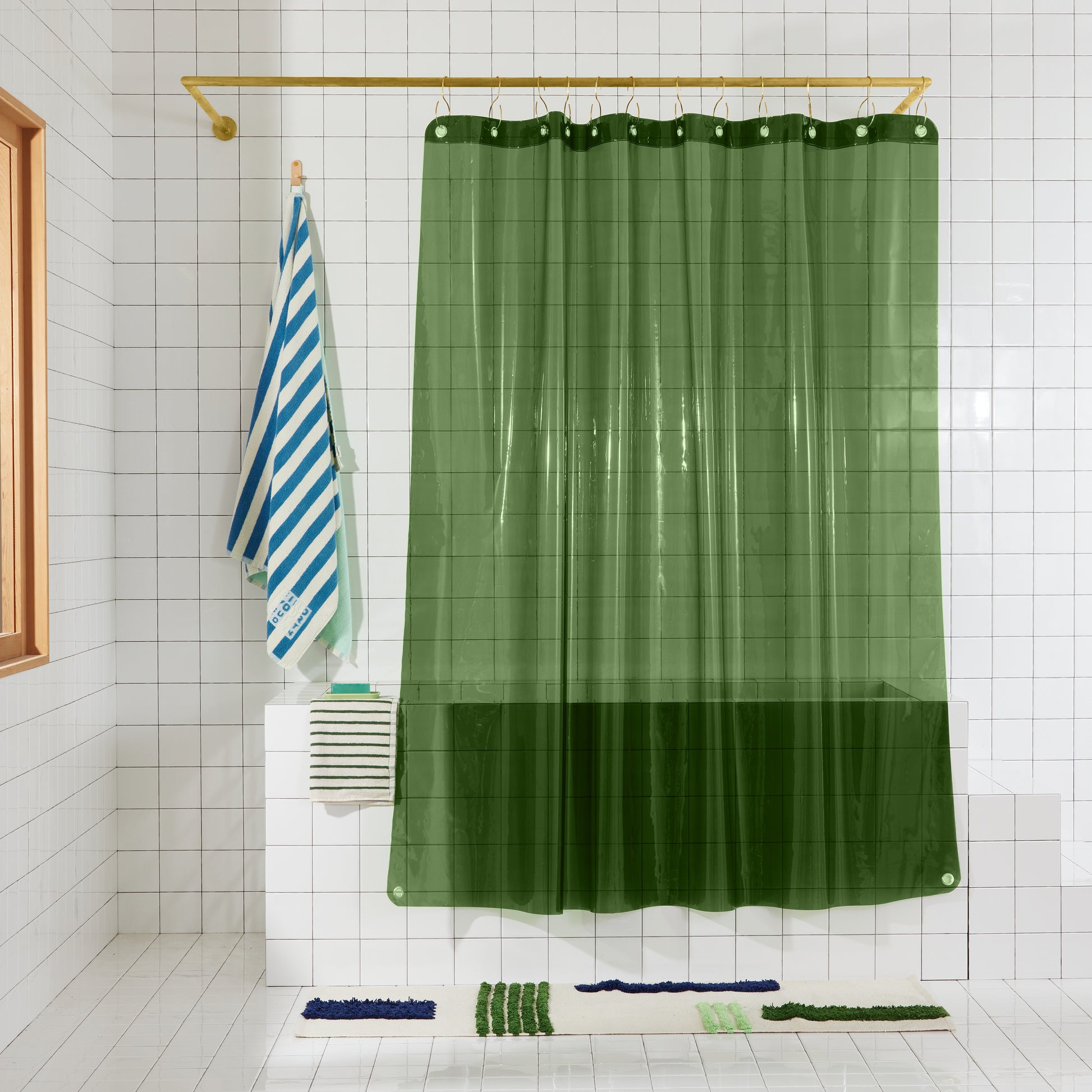 pine green transparent shower curtain hanging in white bathroom. 