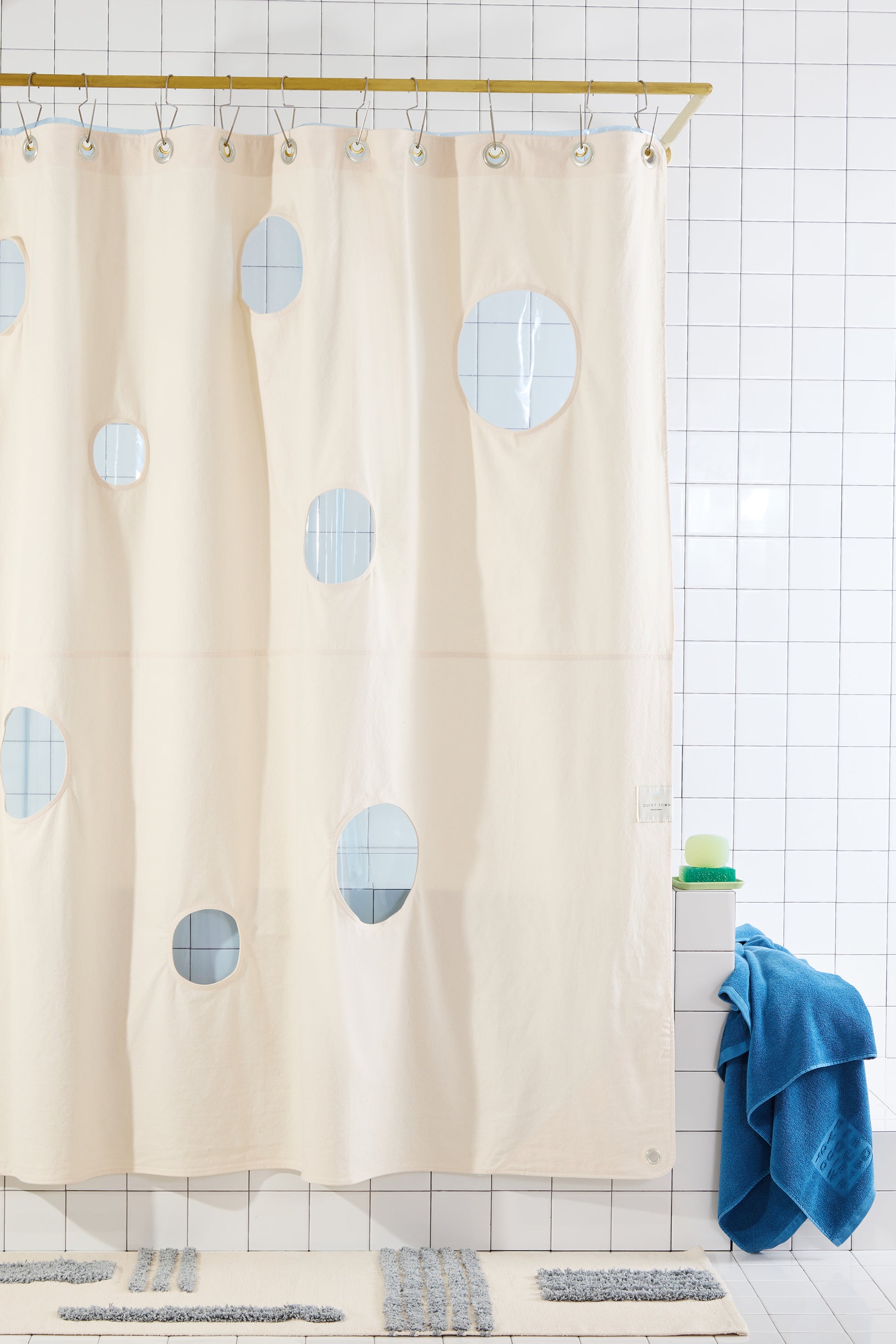 Bubble Sand front view of curtain hanging in a bathroom layered with Sun Shower Atlantic