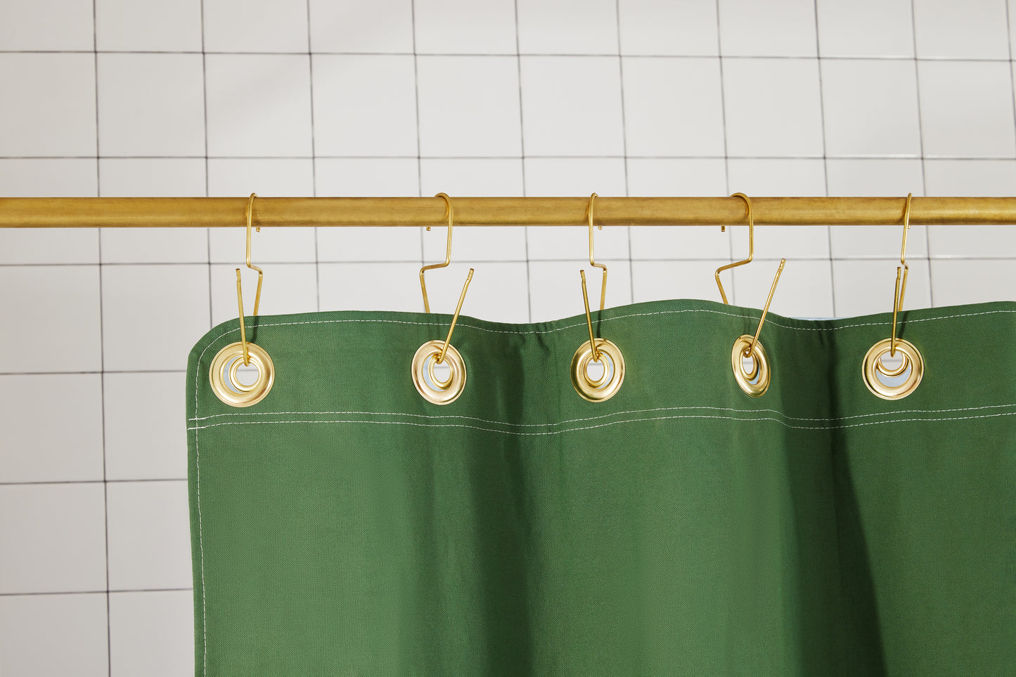 Bubble Pine detail view of grommets and hooks hanging from shower curtain rod.