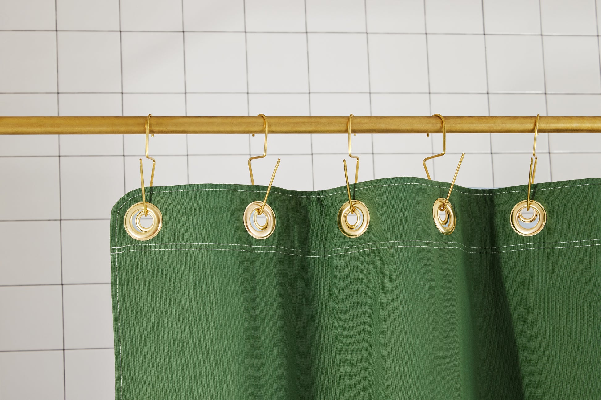 Bubble Pine detail view of grommets and hooks hanging from shower curtain rod.