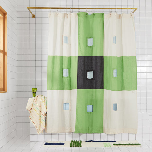 photo of green and charcoal checker linen curtain henging in bathroom.
