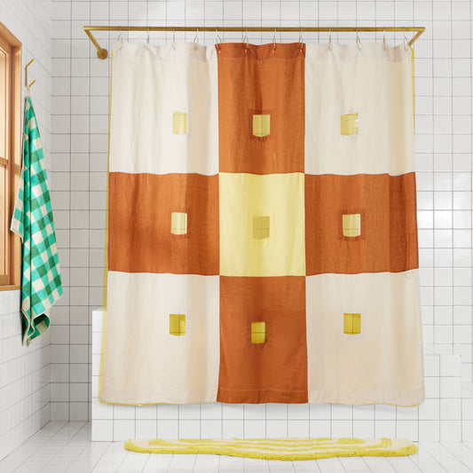 Clay and yellow checker linen shower curtain hangs in bathroom