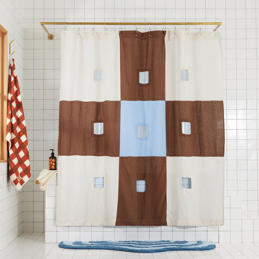 blue and brown checker linen shower curtain with cut-outs hangs in bathroom