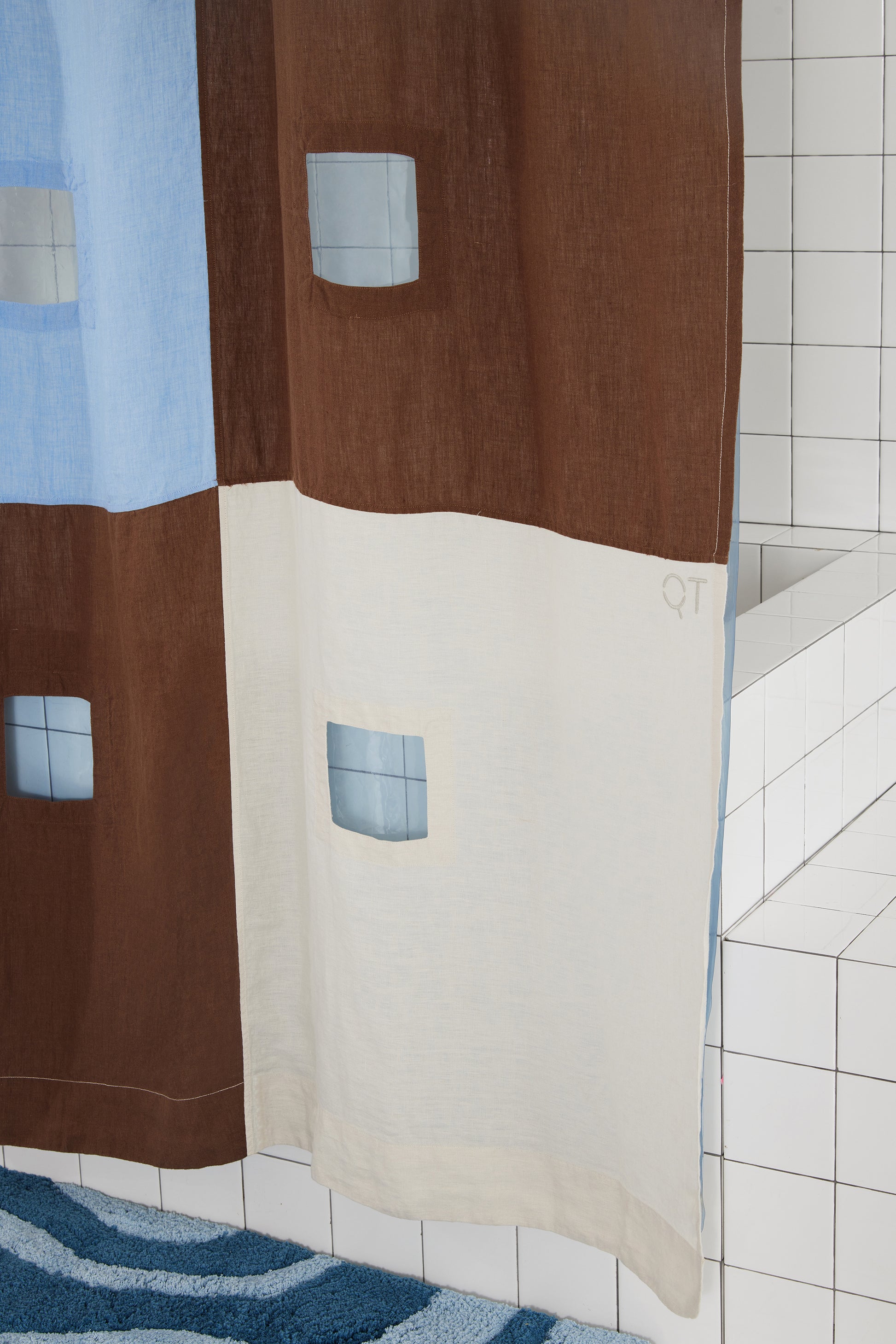 photo of bottom right corner of blue and brown checker linen shower curtain.