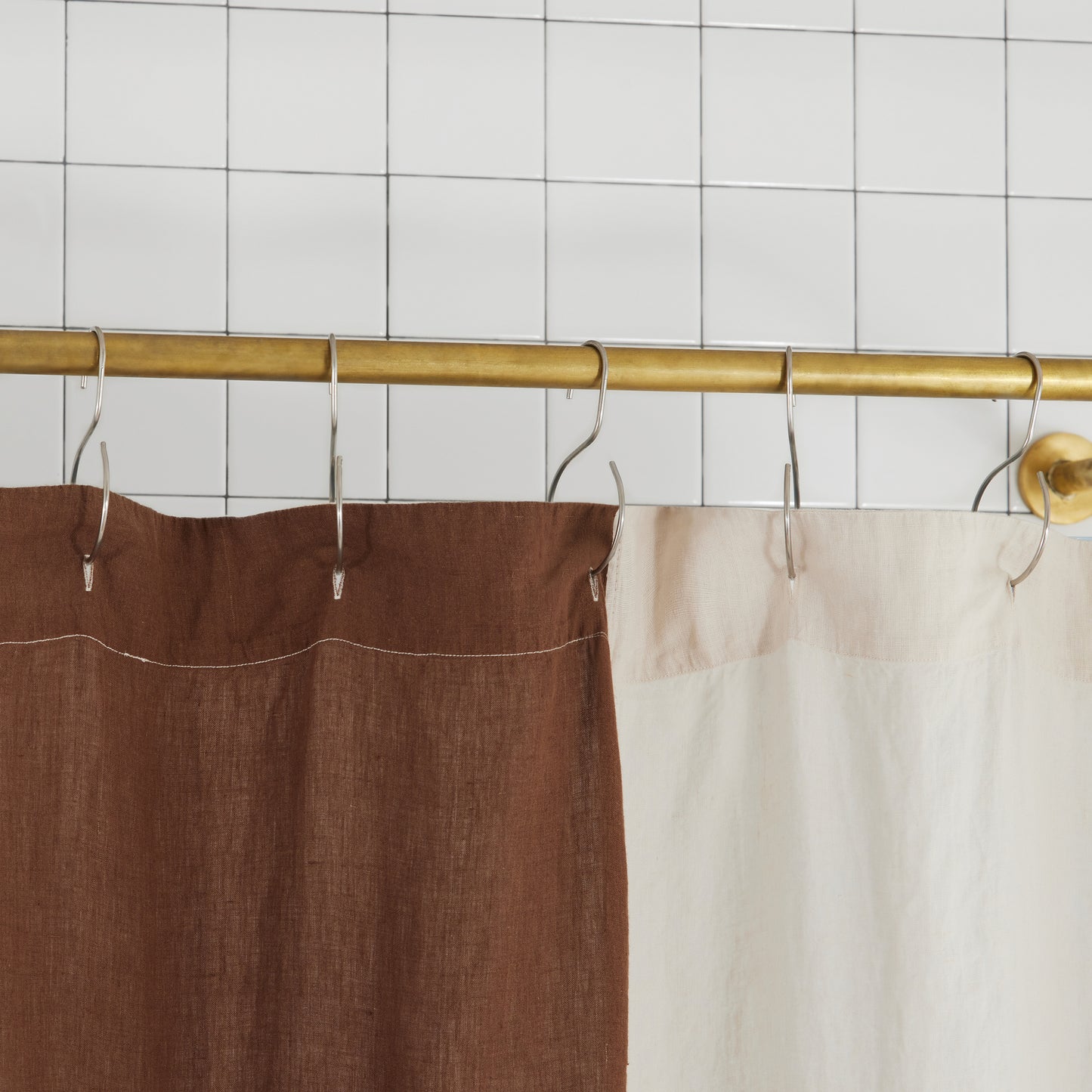 top hem of blue and brown checker linen shower curtain to show button holes for shower curtain hooks to hang from.