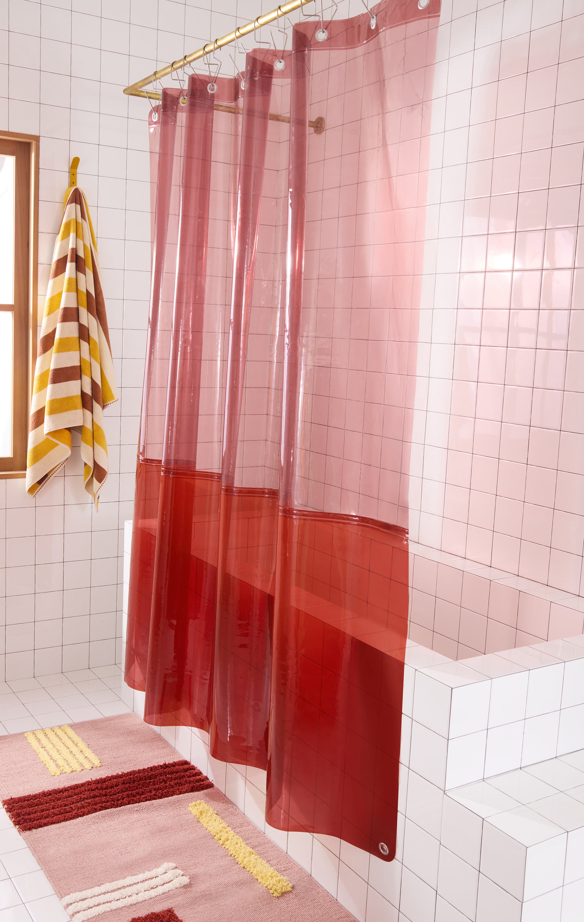 color blocked shower curtain hanging in white tiled bathroom. 